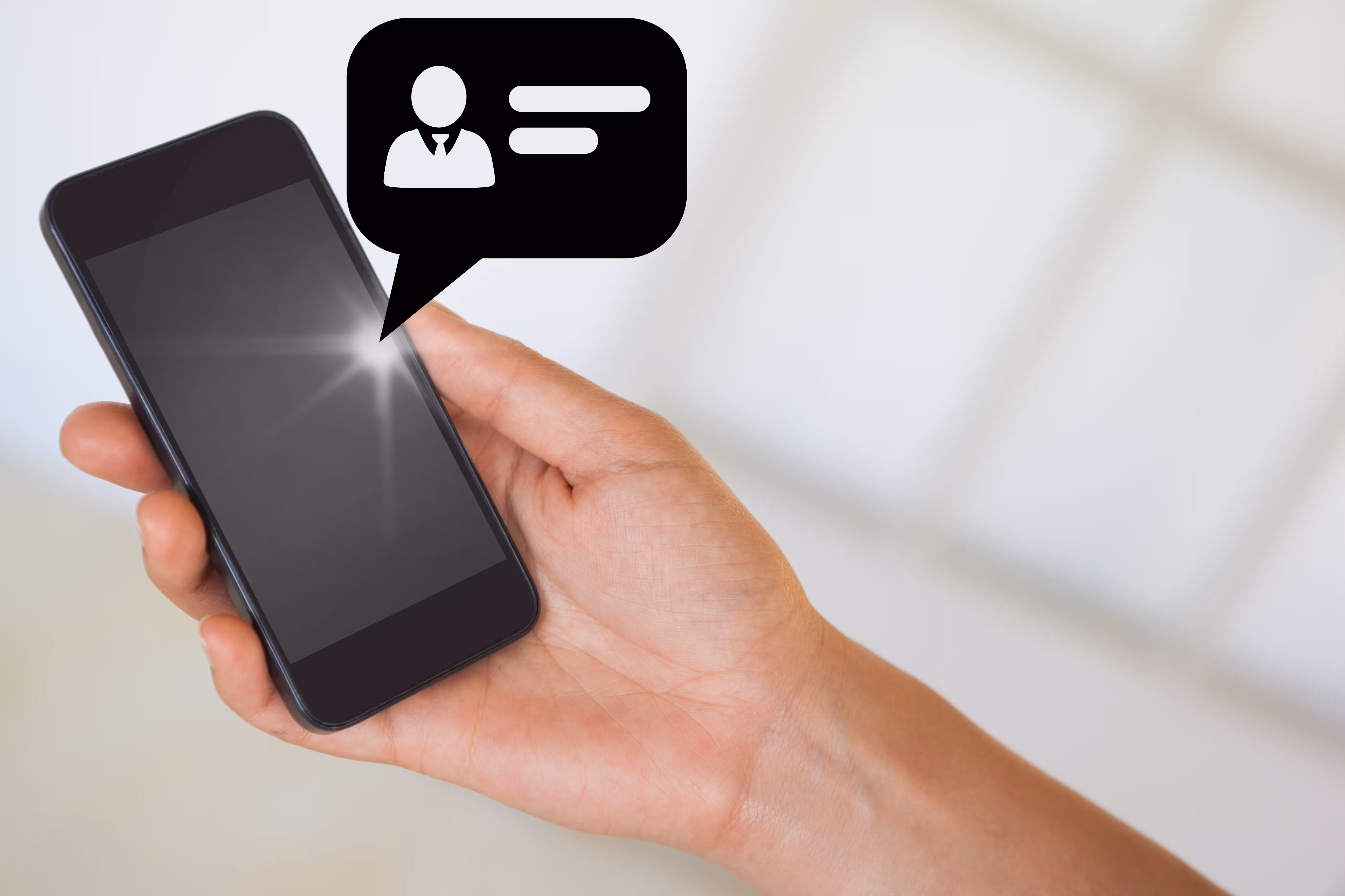 Ruka koja drži pametni telefon sa balončićem poruke korisničkog profila koji prikazuje kontakt informacije